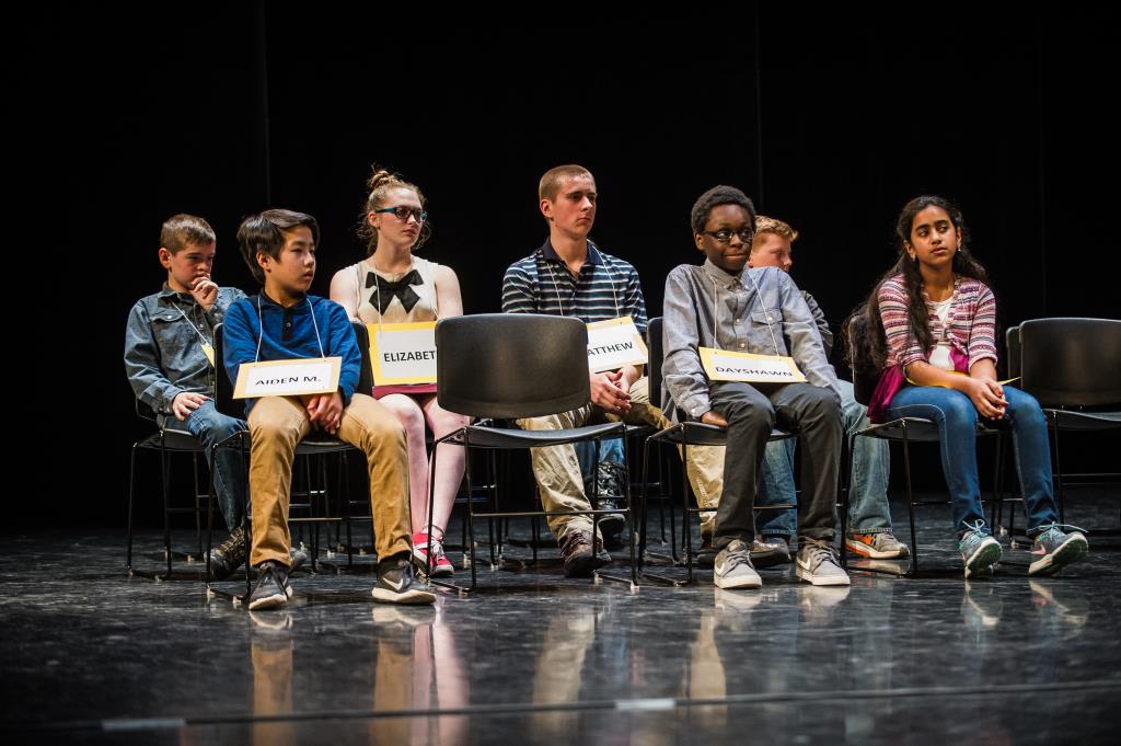 A small group of Spelling Bee contestants wait patiently for their turn at the microphone