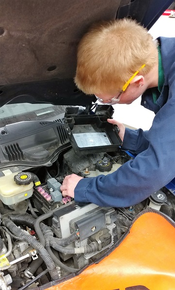 Student checking car engine
