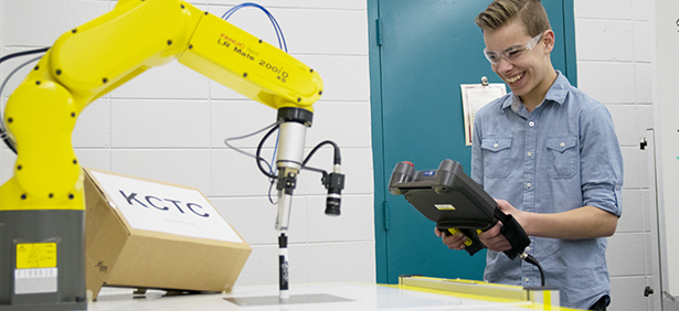 A Mechatronics student operating a robotic arm