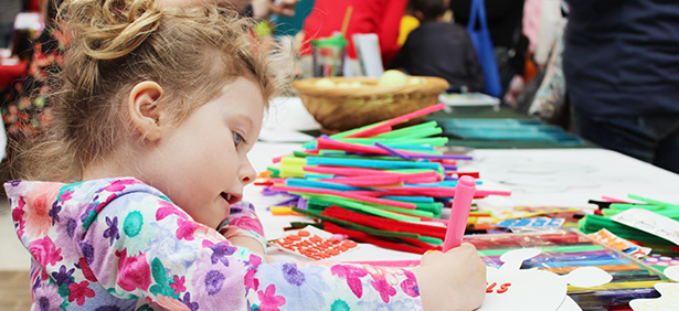 Preschool student practices coloring at an early childhood event