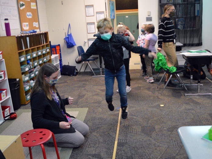 Student jumping like a squirrel for a science experiment.