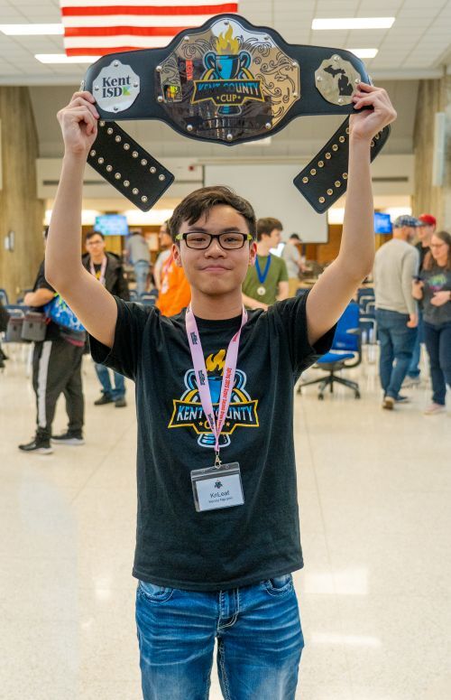 Kenny Nguyen holding a championship belt over his head in celebration