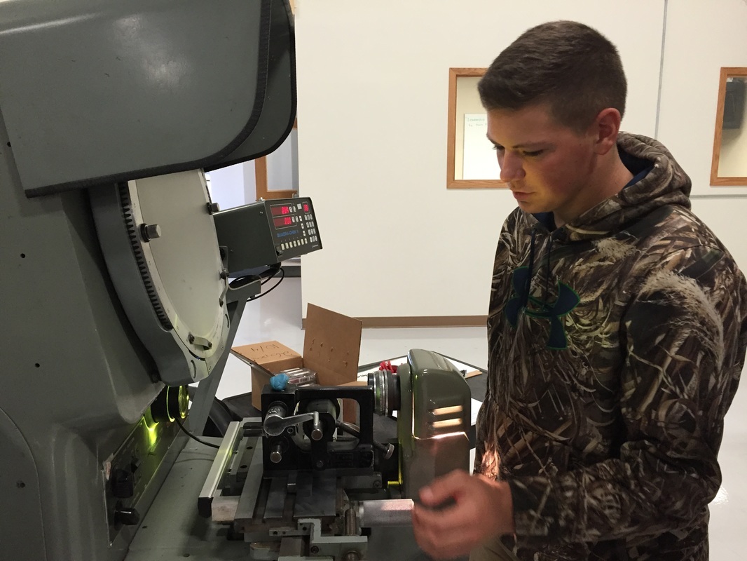 Photo of student using machine at local company.